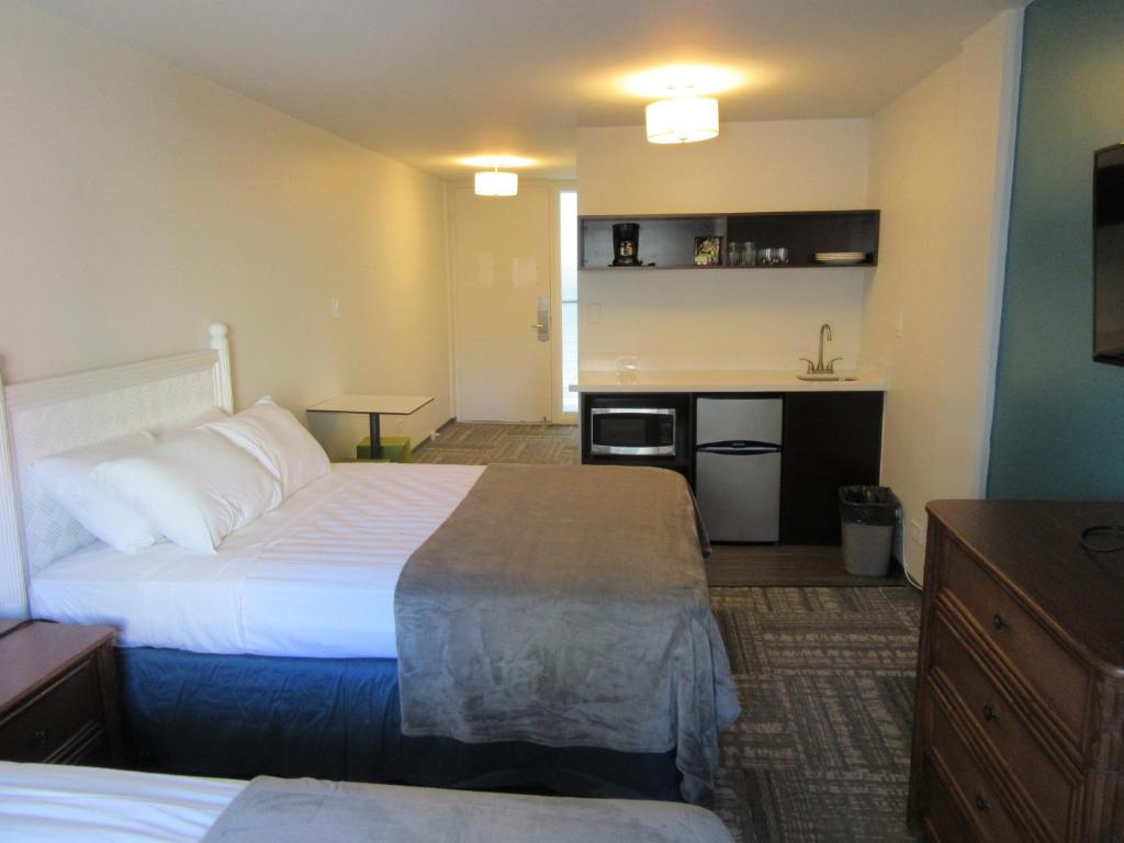 a hotel room with two beds and a kitchen at Waikiki Central Hotel - No Resort Fees in Honolulu