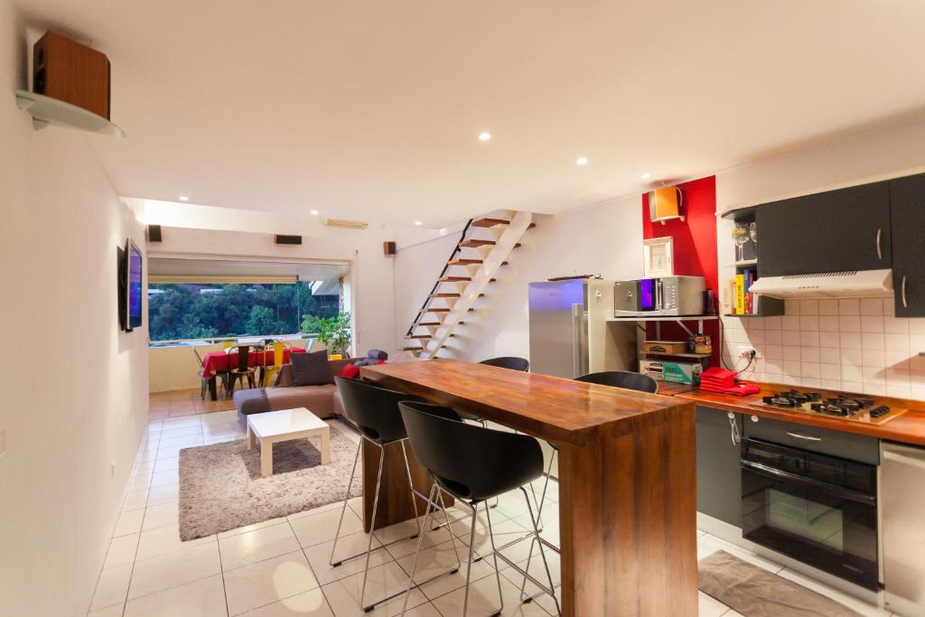 a kitchen and living room with a table and chairs at Vue Lagon et MOOREA in Taapuna
