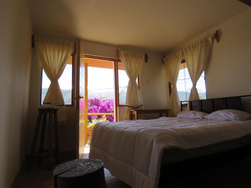 a bedroom with a bed and a large window at Schatzi Lodge in Huaraz