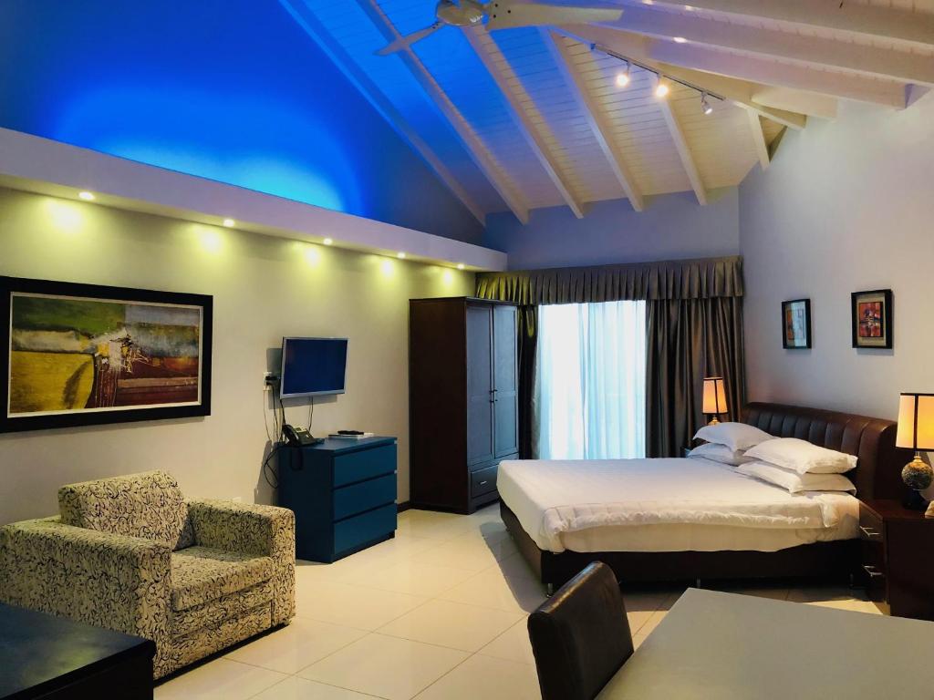 a hotel room with a bed and a chair at Quints Travelers Inn in Willemstad