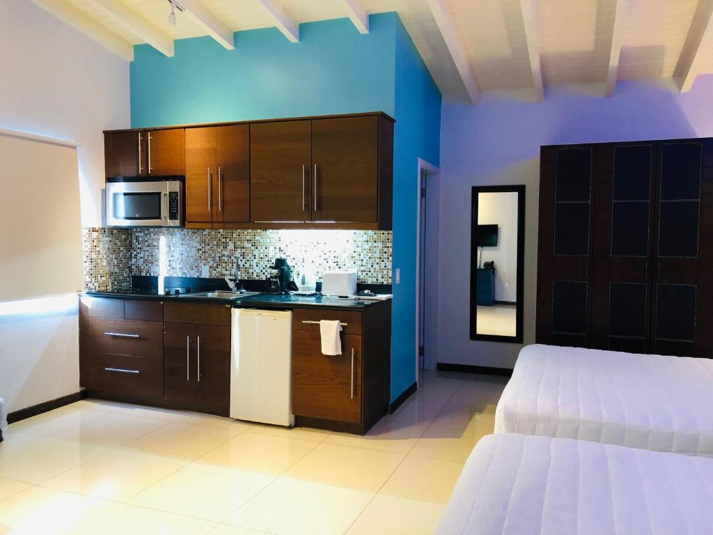 a kitchen with wooden cabinets and a bed in a room at Quints Travelers Inn in Willemstad