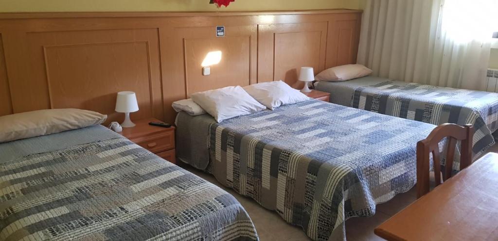 a room with two beds and two lamps at Hostal Brunete in Brunete