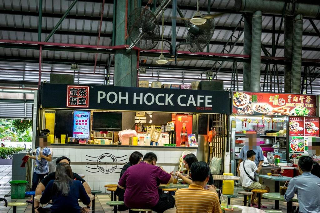 a group of people sitting at tables at a food stand at Super 8 Hotel @ Bayan Baru in Bayan Lepas