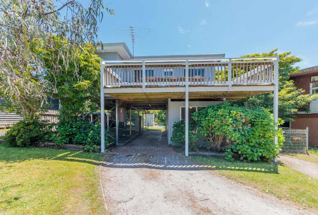 a house with a porch with a wooden deck at INVERLOCH BEACH HUT - CLOSE TO BEACH AND SHOPS! in Inverloch