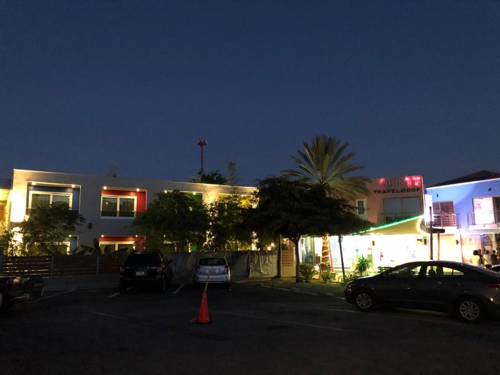 a building with cars parked in a parking lot at night at Quints Travelers Inn in Willemstad