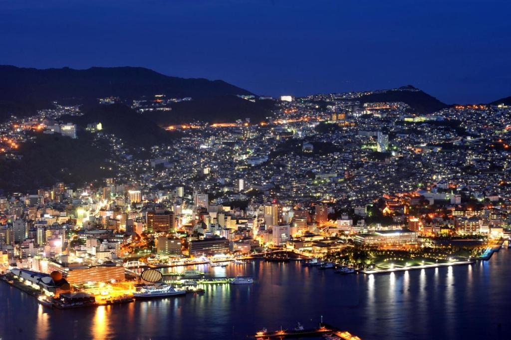 uma vista da cidade à noite em Inasayama Kanko Hotel em Nagasaki