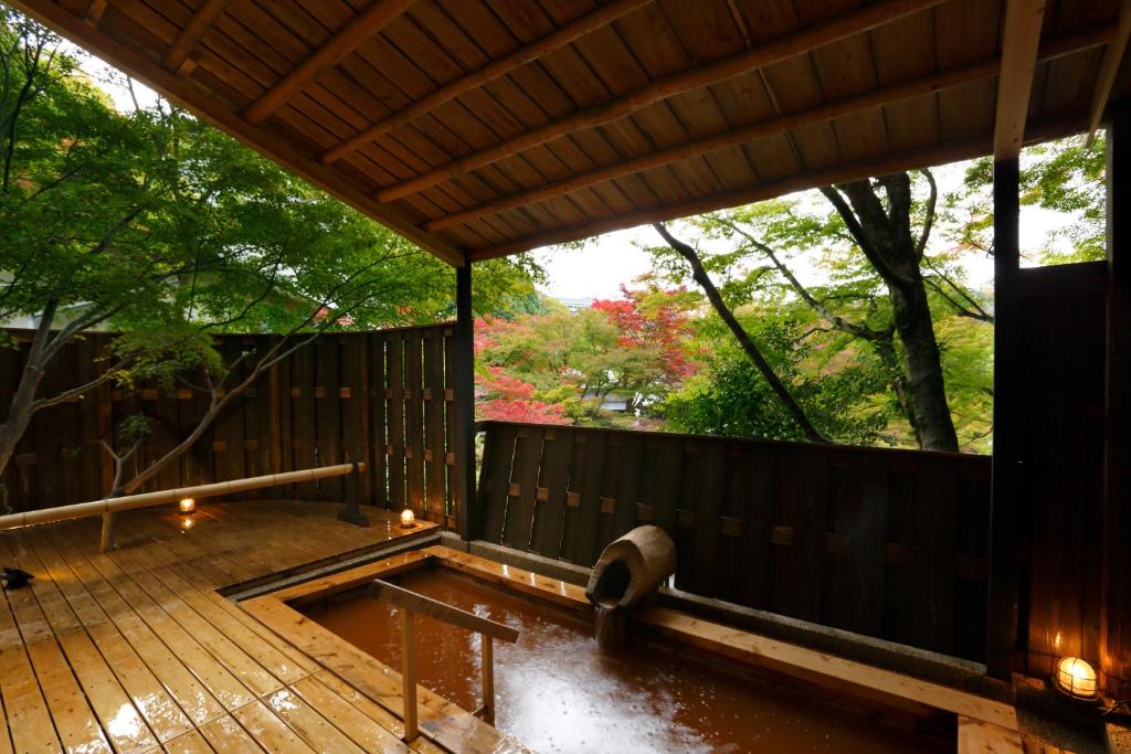 a wooden deck with a pool in the middle at Negiya Ryofukaku in Kobe