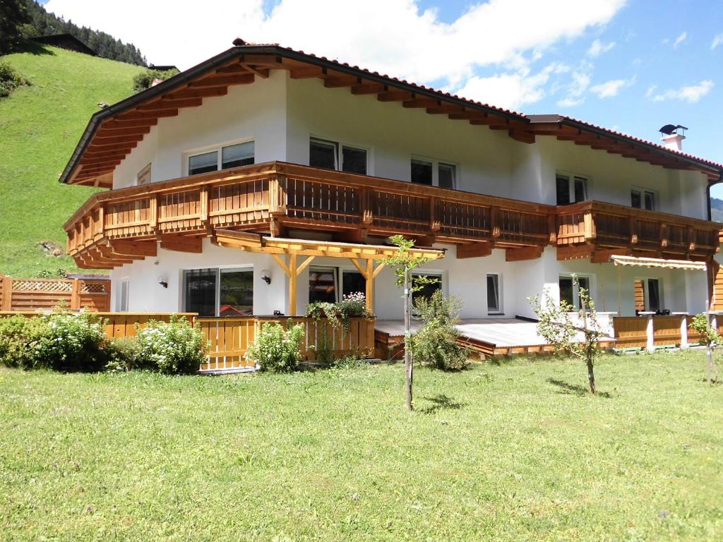 ein großes Haus auf einem Hügel mit Hof in der Unterkunft Appartementhaus Gleirscher in Neustift im Stubaital