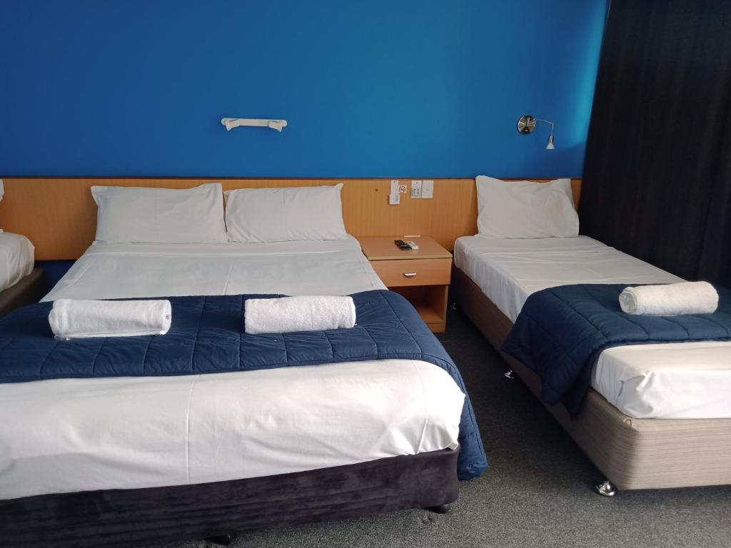 Tempat tidur dalam kamar di Annerley Motor Inn