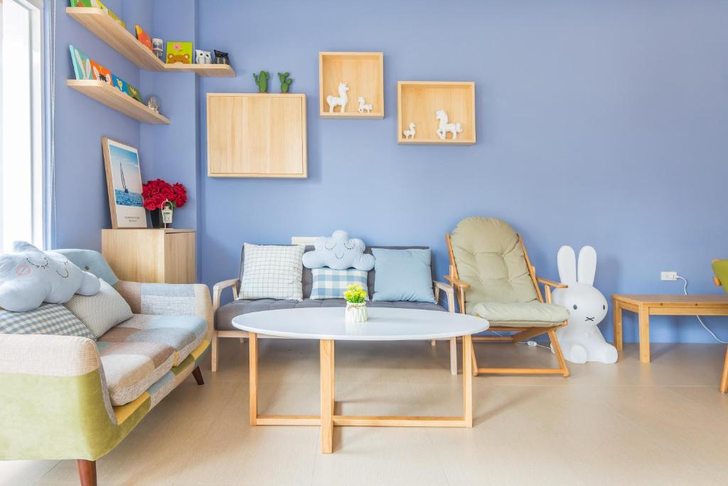 een woonkamer met een bank en een tafel en stoelen bij Penghu Clouds in Magong