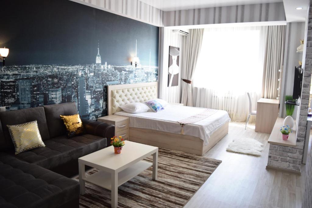 una camera d'albergo con un letto e un divano di FlatRent apartment a Bishkek