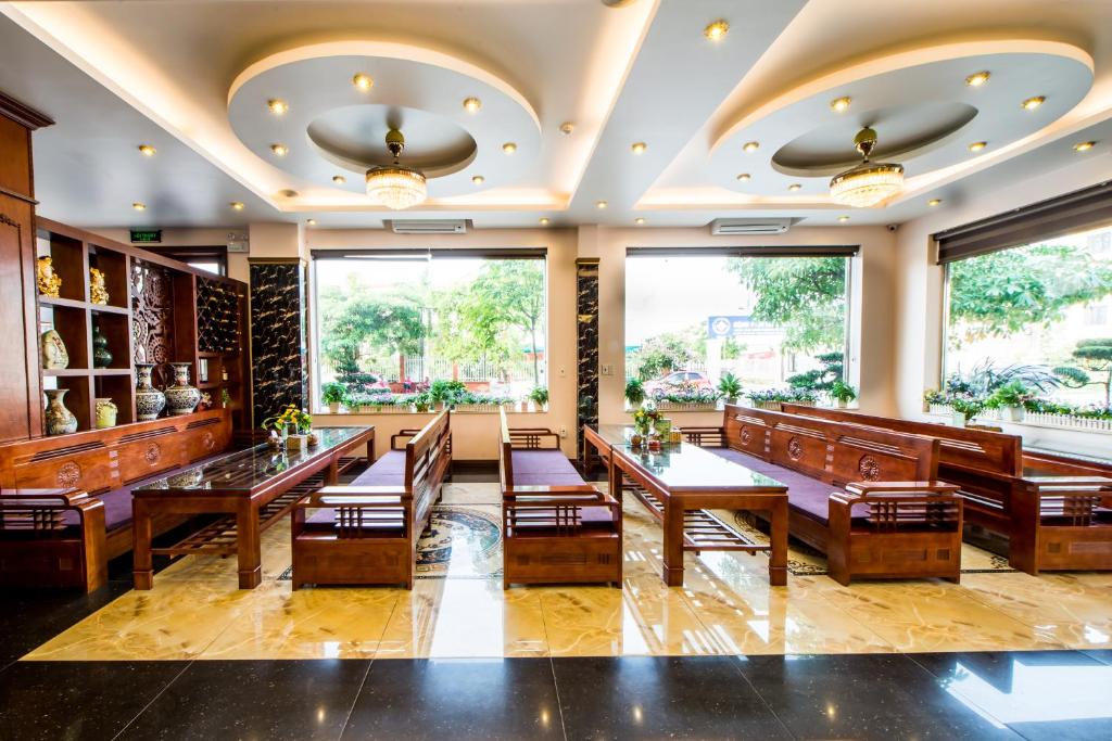 a restaurant with wooden tables and chairs and large windows at ĐẠI THÀNH PHÚC in Hai Phong