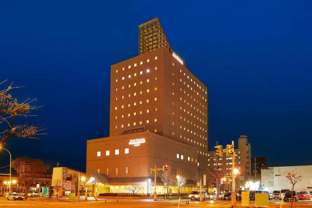 um edifício alto numa cidade à noite em ART HOTEL Aomori em Aomori