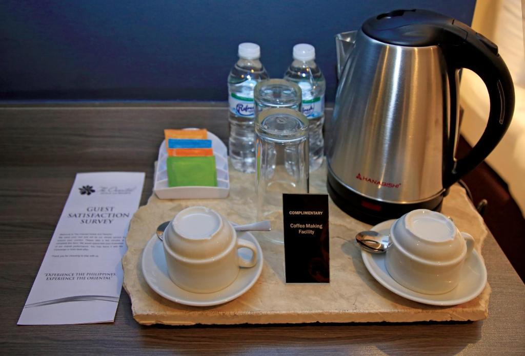 a table with a coffee pot and two cups on a tray at PROXY by The Oriental Albay in Legazpi