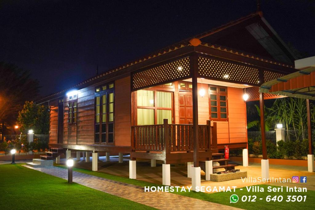 una pequeña casa con porche por la noche en Homestay Segamat - Villa Seri Intan, en Segamat