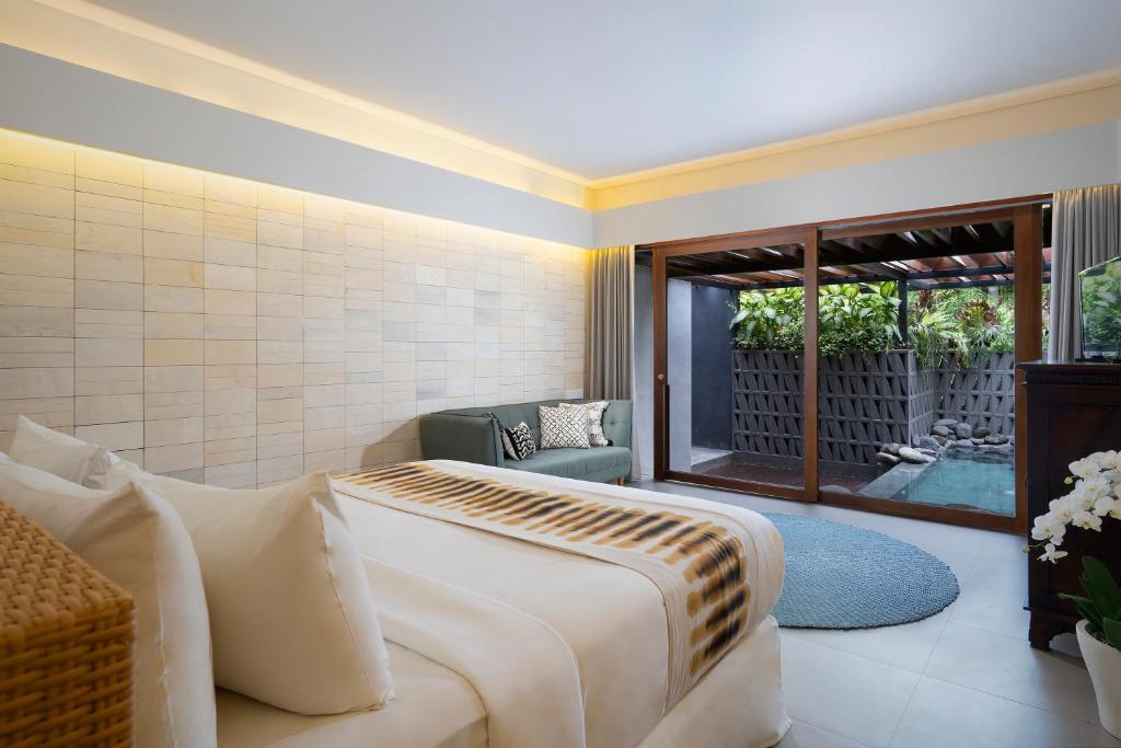 a hotel room with a bed and a patio at The Kemilau Hotel & Villa Canggu Bali in Canggu