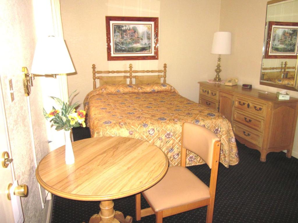 una camera d'albergo con un letto, un tavolo e una scrivania di Color Country Motel a Panguitch