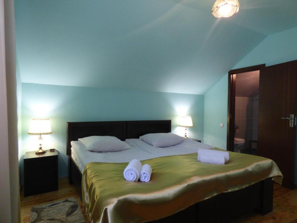 sypialnia z łóżkiem z 2 ręcznikami i 2 lampami w obiekcie Anano Guest House w mieście Stepancminda