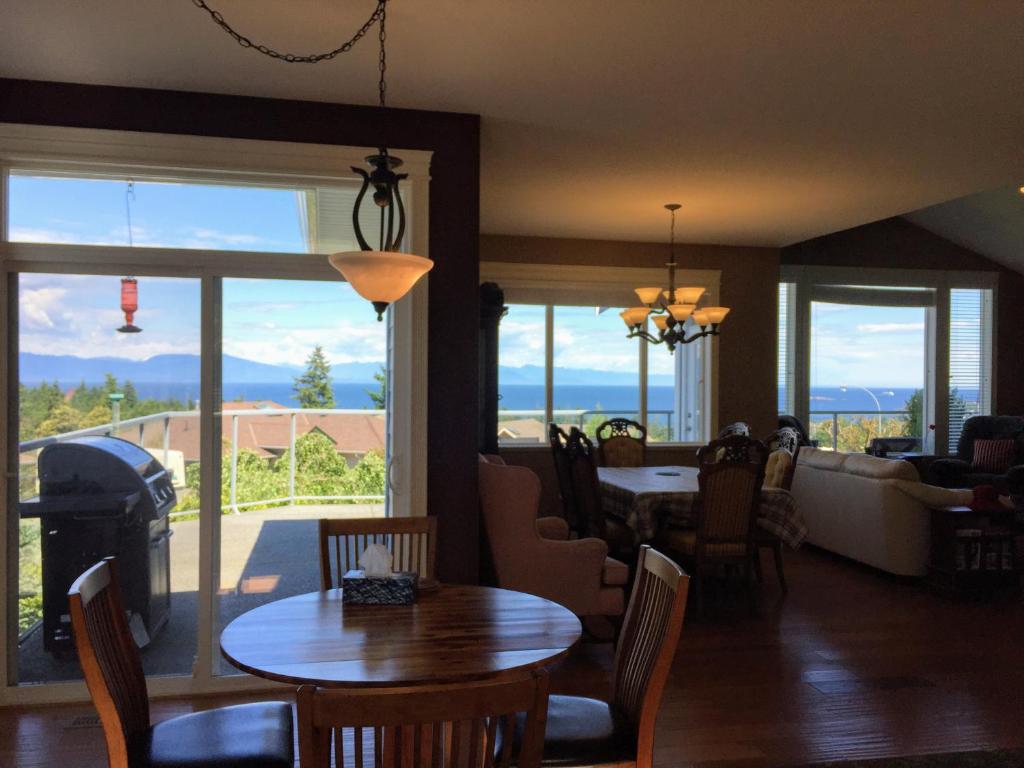 uma sala de estar com mesas e cadeiras e uma lareira em NeckPoint Treasure BnB em Nanaimo