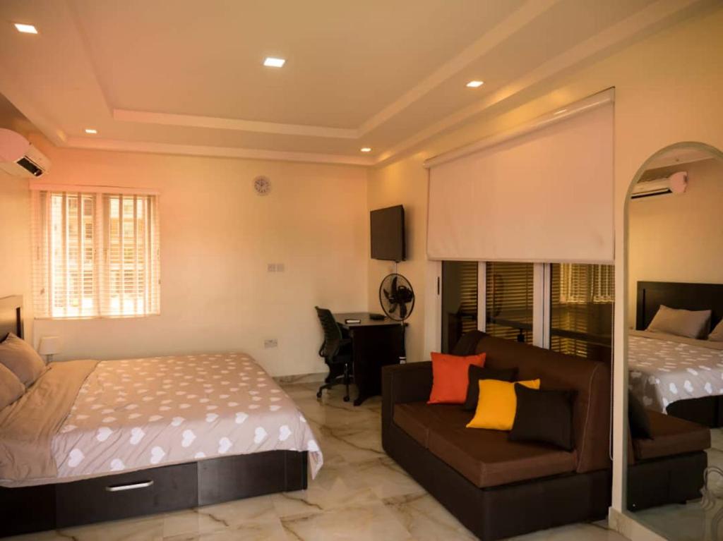 una camera con un letto, un divano e un letto di Zion Place a Ikeja