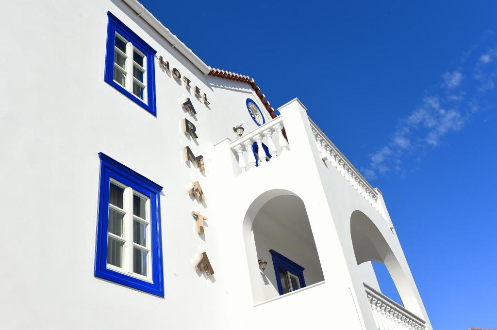 a white building with blue windows against a blue sky at Armata Boutique Hotel in Spetses