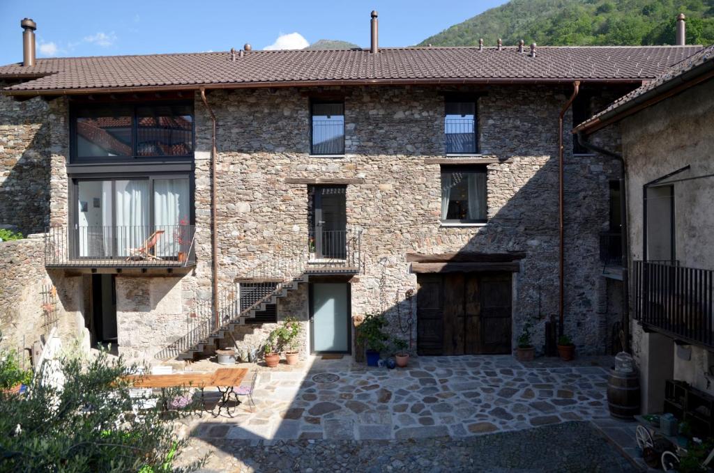 ein Steinhaus mit einem Innenhof und einer Terrasse in der Unterkunft Antica Sosta dei Viandanti in Cadenazzo