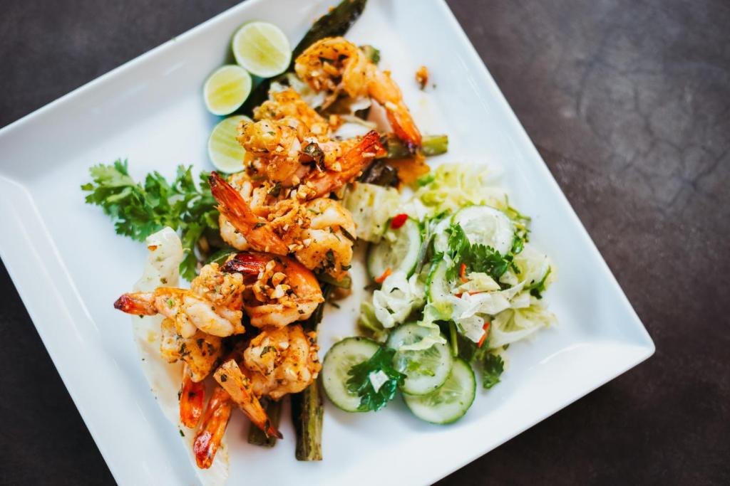 a white plate of food with shrimp and vegetables at Amal Beach Hotel in Bentota