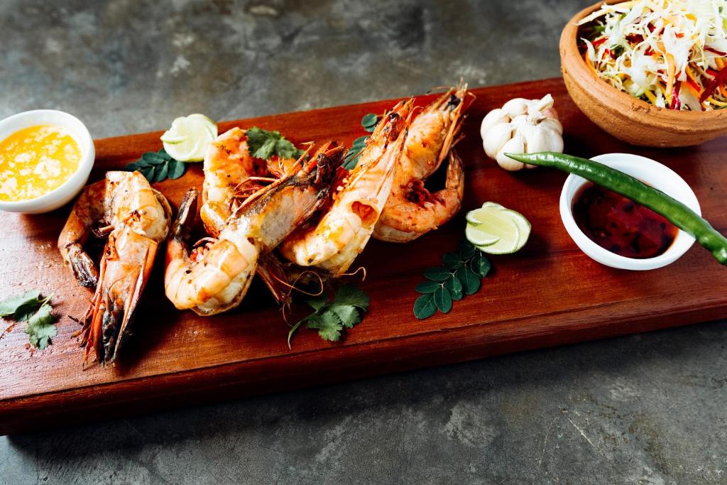 a plate of food with shrimp and vegetables on a table at Amal Beach Hotel in Bentota