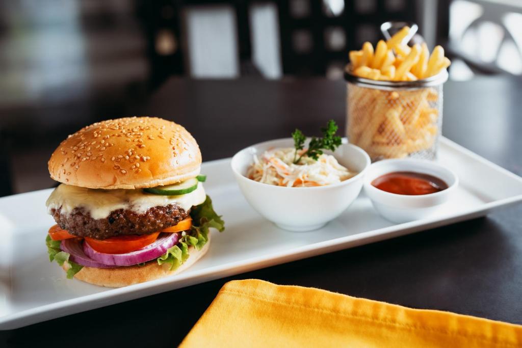 a plate of food with a hamburger and french fries at Amal Beach Hotel in Bentota