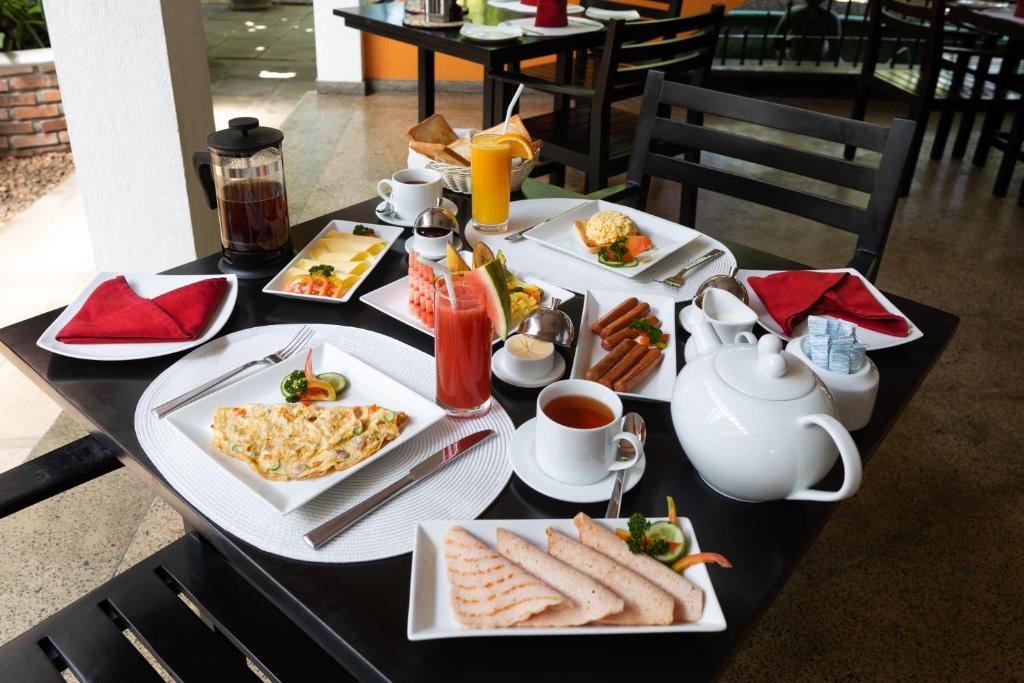 a table with plates of breakfast food on it at Amal Beach Hotel in Bentota
