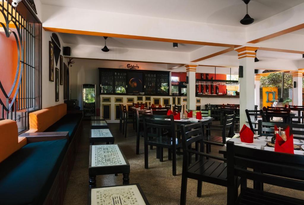 a restaurant with tables and chairs with red napkins at Amal Beach Hotel in Bentota