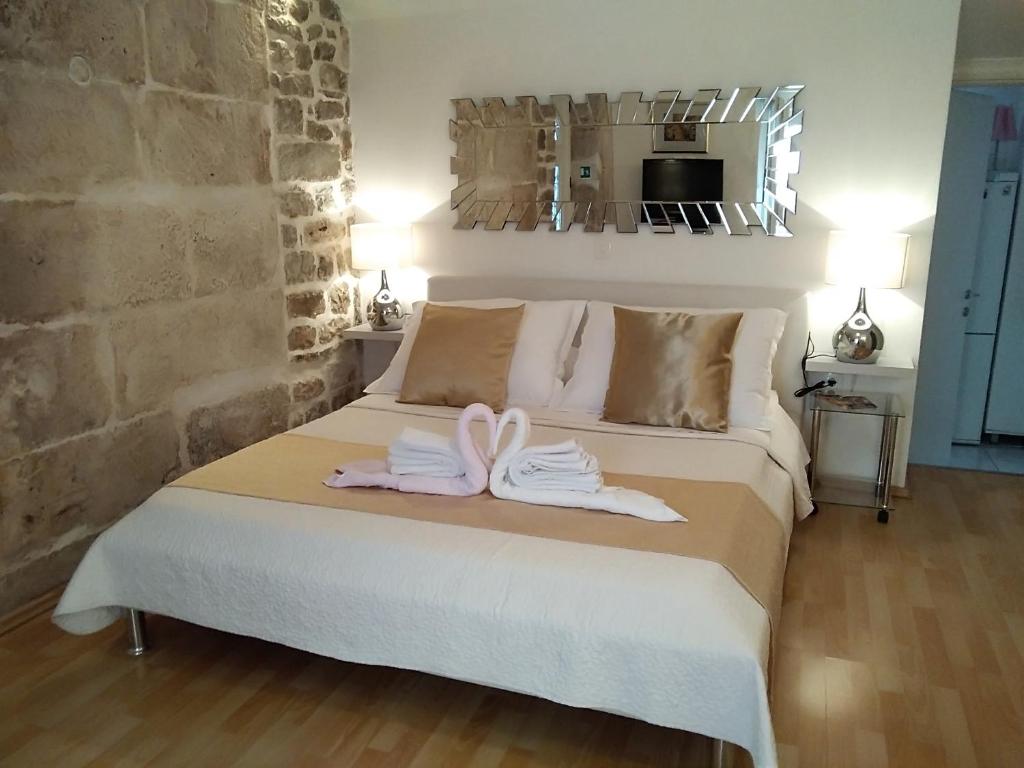 een slaapkamer met een bed met handdoeken erop bij Private Apartments In Diocletians Palace in Split