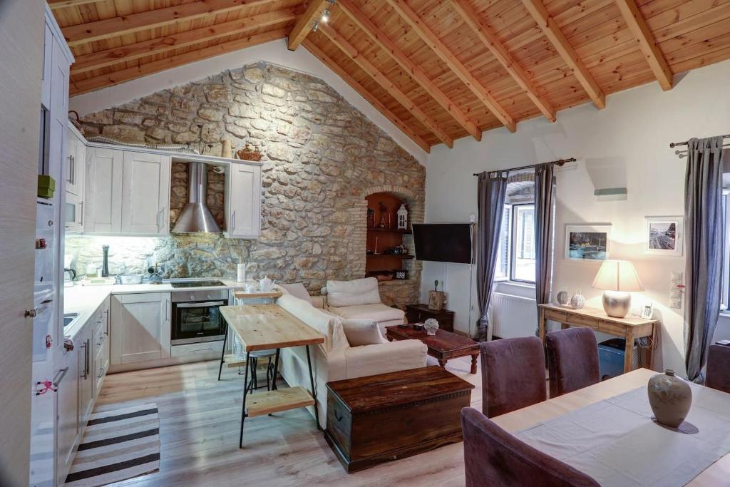 a kitchen and living room with a stone wall at Luminous 2BD stone Apt in the alleys of Corfu town in Corfu