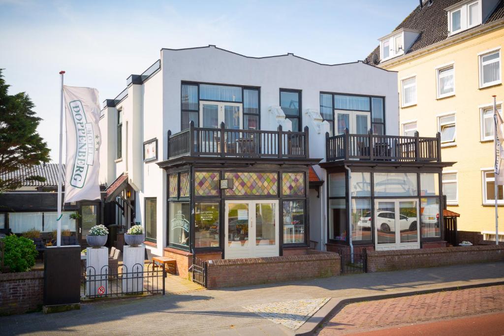 un grande edificio bianco con balconi su strada di Hotel Doppenberg a Zandvoort