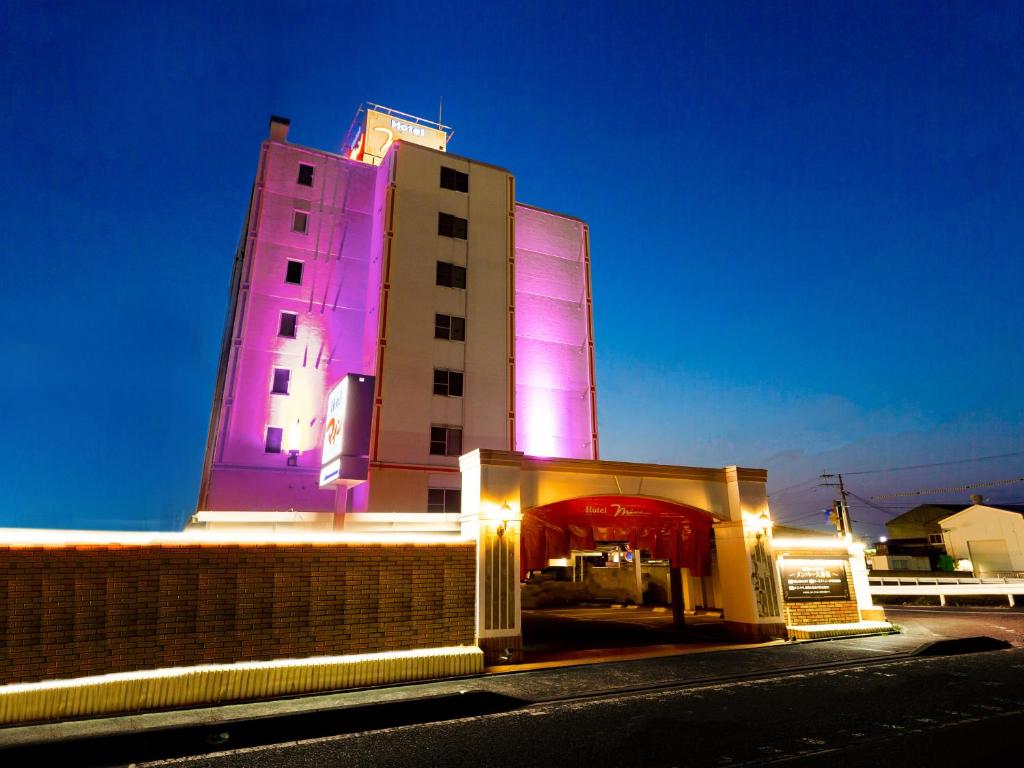 un edificio con luces púrpuras en el lateral. en Hotel Mine (Love Hotel), en Kurume