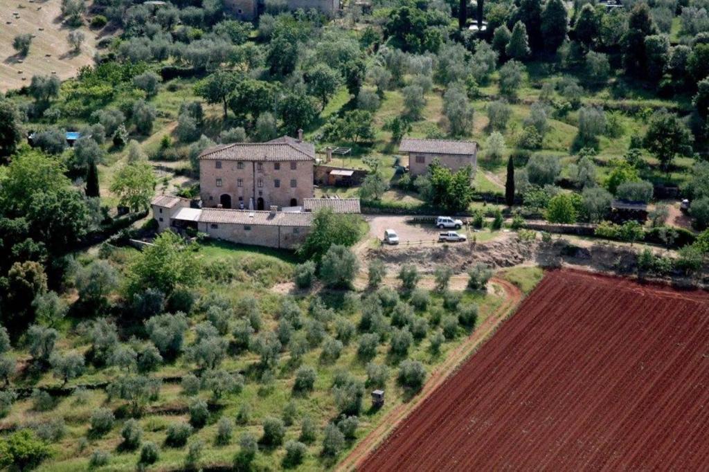 an aerial view of a house and a field at Colors Tastes in the Montagnola Senese in Valiano 