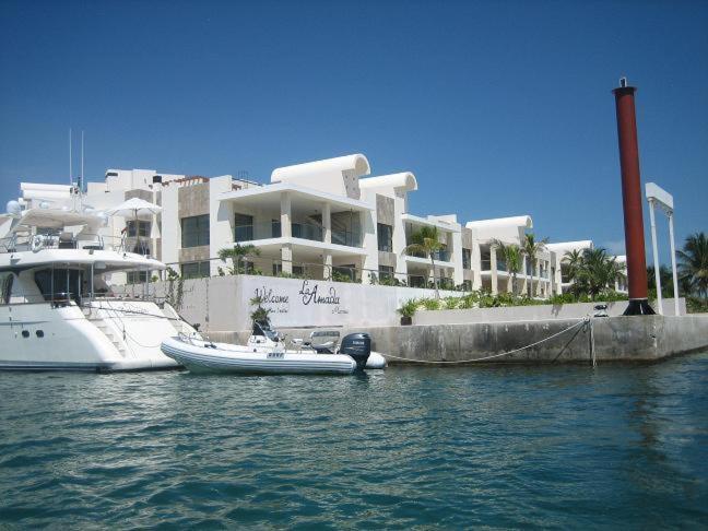 un bateau est amarré devant un grand bâtiment dans l'établissement La Amada Residences Luxury, à Cancún