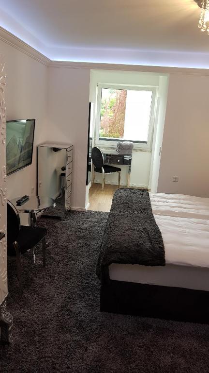 a bedroom with a bed and a desk and a television at Pension Gockels-Auszeit in Bad Wildungen