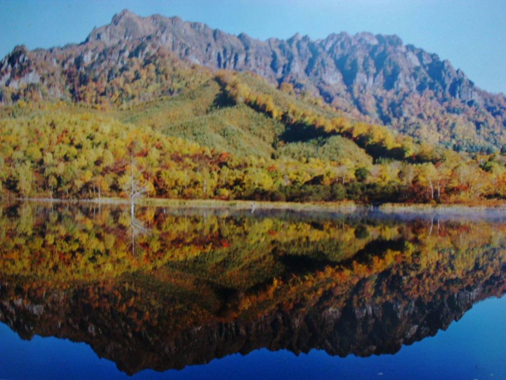 um reflexo de uma montanha na água em Togakushi- Kogen Minshuku Rindo em Nagano