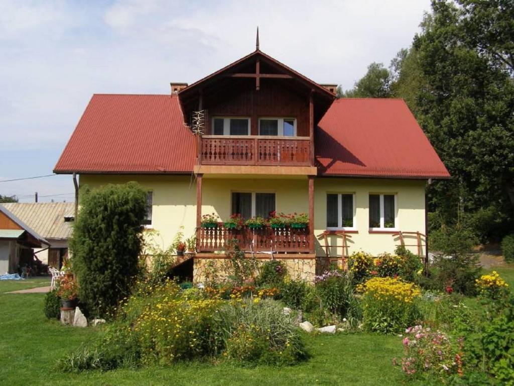 uma casa com um telhado vermelho e uma varanda em Gospodarstwo Agroturystyczne Dolina Zachwytu em Sułoszowa