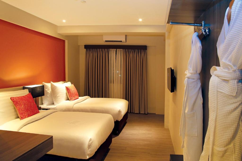 a hotel room with two beds and a table at PROXY by The Oriental Albay in Legazpi