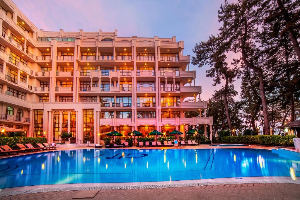 a hotel with a swimming pool in front of a building at Kobuleti Georgia Palace Hotel & Spa in Kobuleti