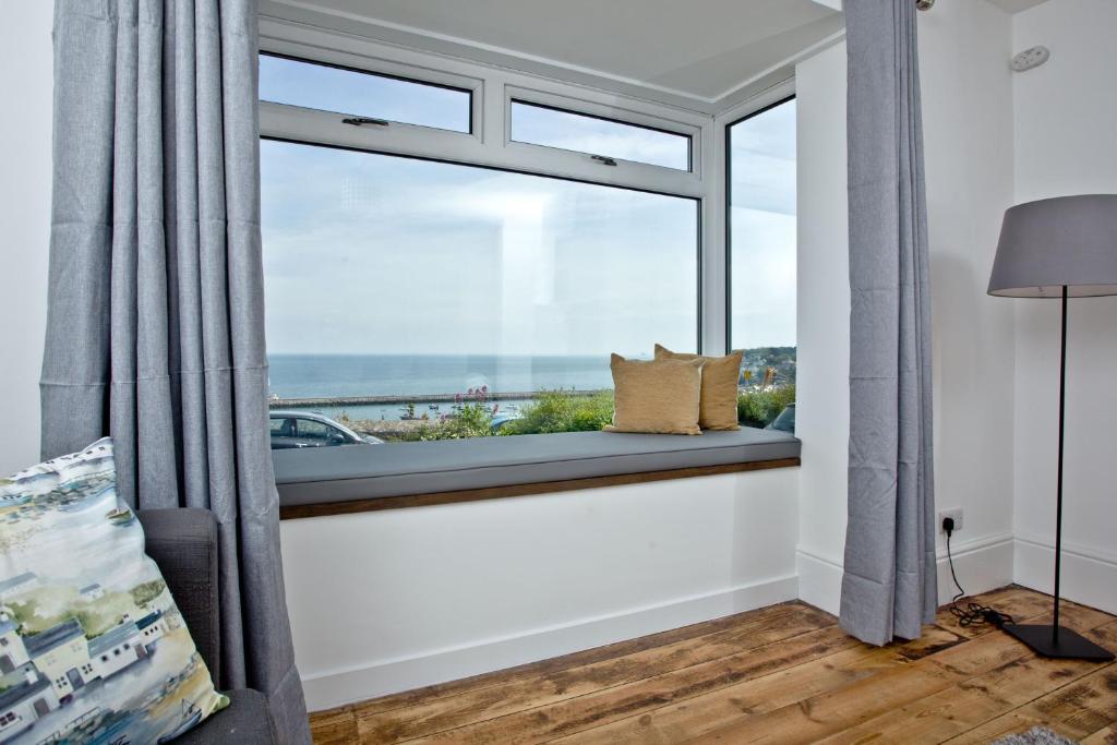 um quarto com um assento na janela com vista para o oceano em Lighthouse View em Brixham