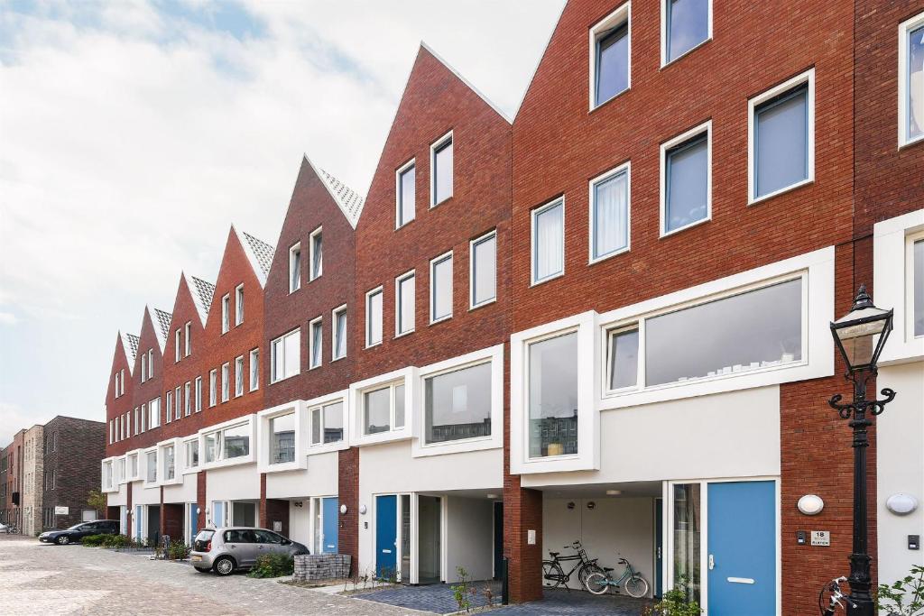 een bakstenen gebouw met witte ramen op een straat bij Canal House - Homestay in Alkmaar