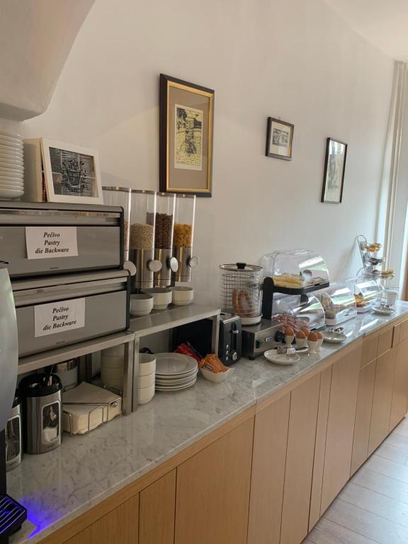 a kitchen with a counter with plates and dishes at Hotel 100 in Pardubice