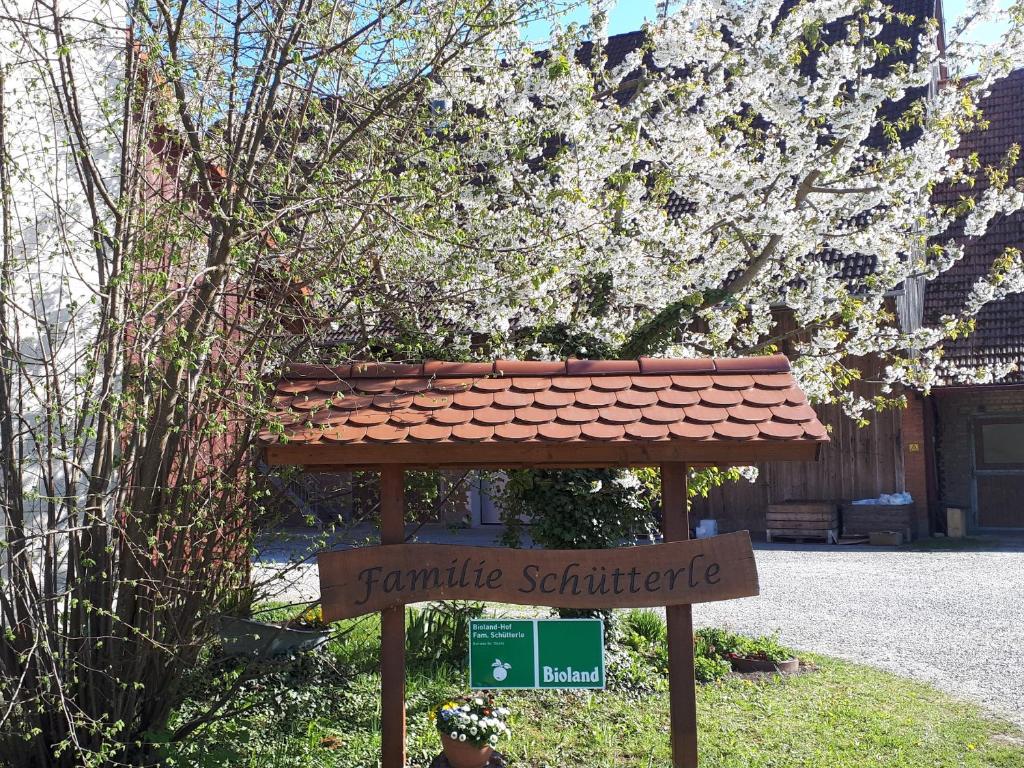 a sign in front of a house with a tree at Hof Schütterle in Friedrichshafen