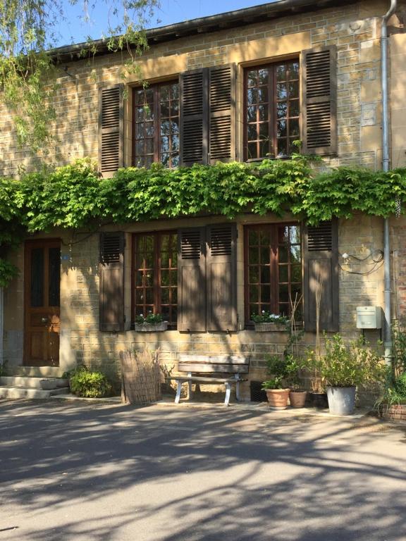 a building with a bench in front of it at Chez Mémère Hélène in Sormonne