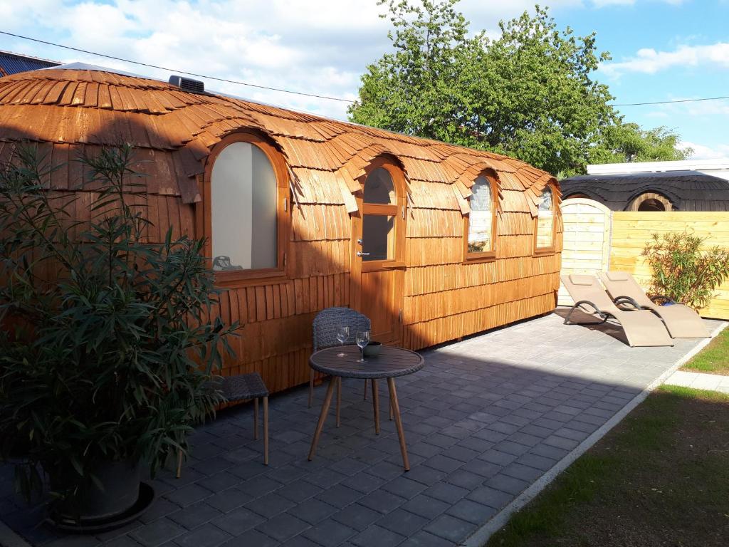 a large wooden house with a table in a yard at Tinyhouse Zollernalb in Balingen