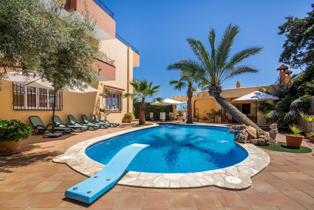 a swimming pool with a slide in a resort at Villa Palmera in Ibiza Town