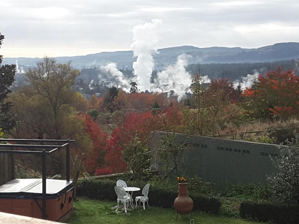 een uitzicht op een vuur in de bergen vanaf een tuin bij Geyser Lookout BnB in Rotorua